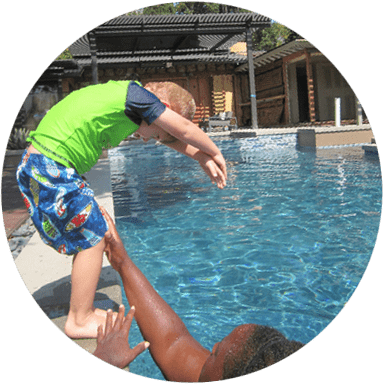 Child jumping into a swimming pool